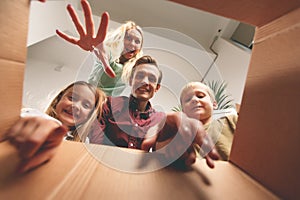 Image of happy parents and children looking inside cardboard box