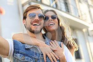 Image of a happy smiling cheerful young couple outdoors take a selfie by camera.