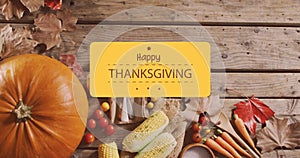 Image of happy thanksgiving day text over vegetables