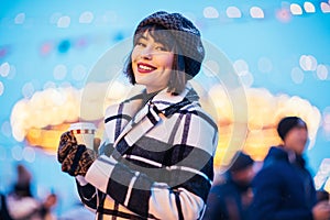 Image of happy woman with glass in hands on walk on street