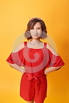 Image of a happy young beautiful asian woman posing isolated over yellow background