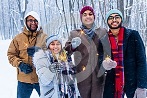 Image of a happy young friends with sparklers at Christmas party