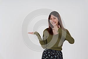 Image of happy young girl standing and Looking camera pointing isolated over white background.