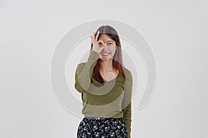 Image of happy young girl standing and Looking camera pointing isolated over white background.