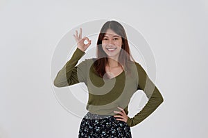 Image of happy young girl standing and Looking camera pointing isolated over white background.