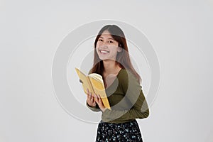 Image of happy young girl standing and Looking camera pointing isolated over white background.