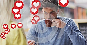 Image of heart icons floating over happy caucasian couple talking and drinking coffee