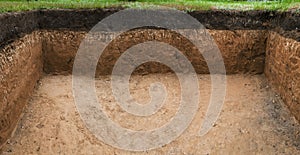 Image of hole in the ground. Soil layer in section. Slice of layers of different structures