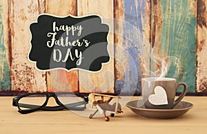 Image of hot coffee or tea, old plane toy and glasses over wooden table. Father`s day concept.