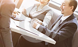 Image of human hand pointing at touchscreen in working environment at meeting