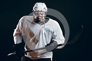 Image of ice-hockey player in white sportswear holding hockey stick