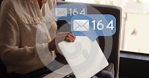 Image of icons and numbers over woman using laptop photo