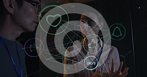 Image of icons over diverse male and female it engineers with tablet by computer server