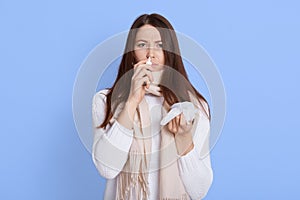 Image of ill woman with running nose, having got flu or catch cold, sneezing in handkerchief, posing isolated on white background