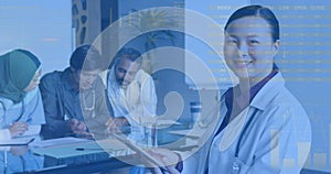 Image of infographic interface over diverse female doctor standing and using digital tablet