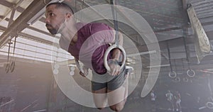 Image of interface processing data over biracial man training on gym rings at gym