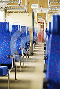 Image with the interior of a Czech train. An older train with comfortable and colorful chairs. - Image