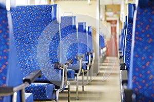 Image with the interior of a Czech train. An older train with comfortable and colorful chairs. - Image