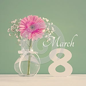 Image of International women day concept with beautiful flower in the vase on wooden table.