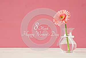 Image of International women day concept with beautiful flower in the vase on wooden table.