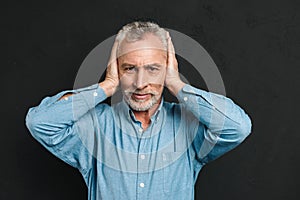 Image of irritated man 50s wearing shirt grabbing his head and c