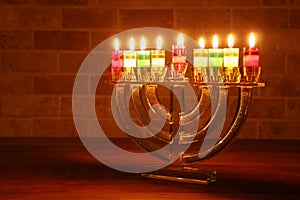 Image of jewish holiday Hanukkah background with crystal menorah traditional candelabra and oil candles