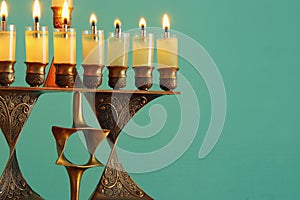 Image of jewish holiday Hanukkah background with menorah & x28;traditional candelabra& x29; and burning candles.