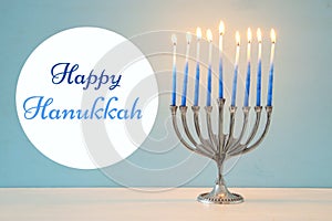 Image of jewish holiday Hanukkah background with traditional menorah & x28;traditional candelabra& x29; and burning candles