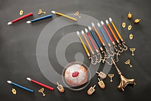 image of jewish holiday Hanukkah background with traditional spinnig top, menorah (traditional candelabra) and burning candles.