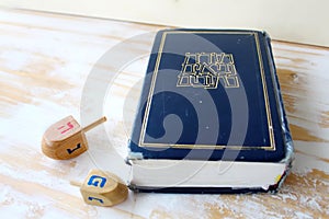 Image of Jewish holiday Hanukkah. Hebrew Bible Tanakh Torah, Neviim, Ketuvim and Wooden dreidels toys Hanukkah, holiday symbols