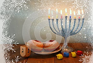 Image of jewish holiday Hanukkah with menorah (traditional Candelabra), donuts and wooden dreidels (spinning top). retro filtered
