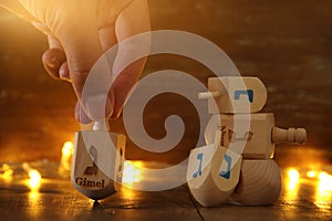 Image of jewish holiday Hanukkah with wooden dreidels colection & x28;spinning top& x29; and gold garland lights