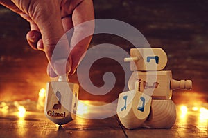 Image of jewish holiday Hanukkah with wooden dreidels colection & x28;spinning top& x29; and gold garland lights