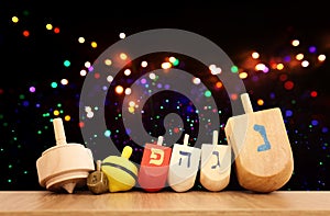 Image of jewish holiday Hanukkah with wooden dreidels collection. Spinning tops with letters that mean, a great miracle happened