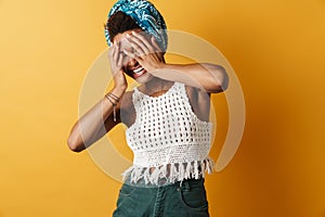 Image of joyful african american woman laughing while covering her face