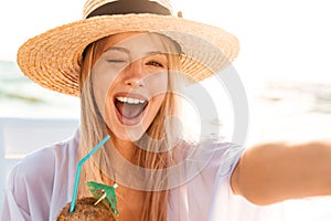 Image of joyful pretty woman 20s in summer straw hat laughing, a