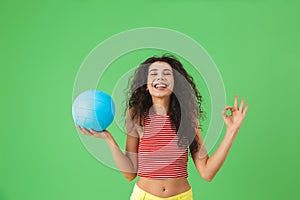 Image of joyful woman 20s wearing summer clothes smiling and holding volley ball