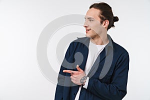 Image of joyful young man looking and pointing finger aside