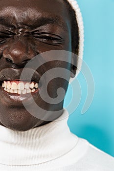 Image of joyous african american guy in white clothes smiling at camera