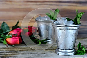 Image for Kentucky Derby in May showing two silver mint julep cups with crushed ice and fresh mint in a rustic setting