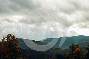 Image of a landscape overlooking mountain forests. The rays of the sun illuminate the forest land. Clouds covered the sky. Travel
