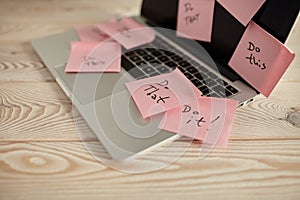 Image of laptop full of sticky notes reminders on screen. Work overload concept image. Coworking or working at home concept image