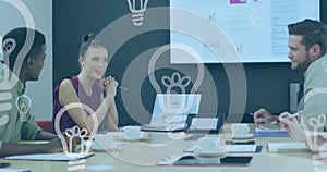 Image of light bulb icons over diverse business people working in office