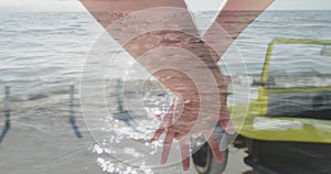 Image of light over hands of caucasian couple walking on beach