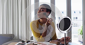 Image of light spots over biracial woman applying make-up