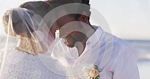 Image of light spots over happy african american groom unveiling bride on beach at wedding