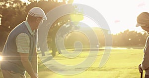 Image of light trails ver senior caucasian couple playing golf on golf course