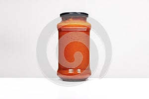 Image of a liter boat of tomato sauce on white surface