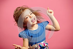 Image of little dancing girl wears beautiful dress on isolated pink background.