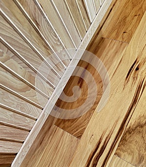 Image looks down to wood floor surrounded by wood cabinets made with narrow slats of wood. Modern new look is seen for interior .